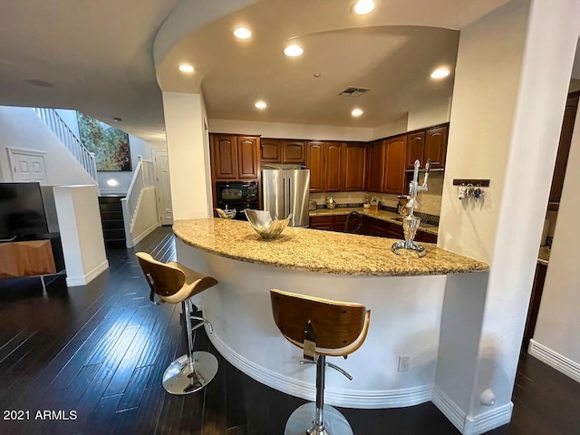 18507 N 94th St, Scottsdale, AZ 85255 - kitchen with a breakfast bar, high quality fridge, light stone counters, and baseboards