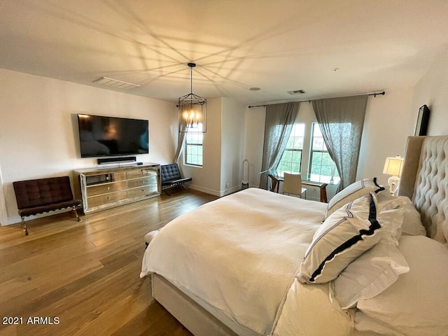 18507 N 94th St, Scottsdale, AZ 85255 - bedroom featuring baseboards, an inviting chandelier, visible vents, and wood finished floors