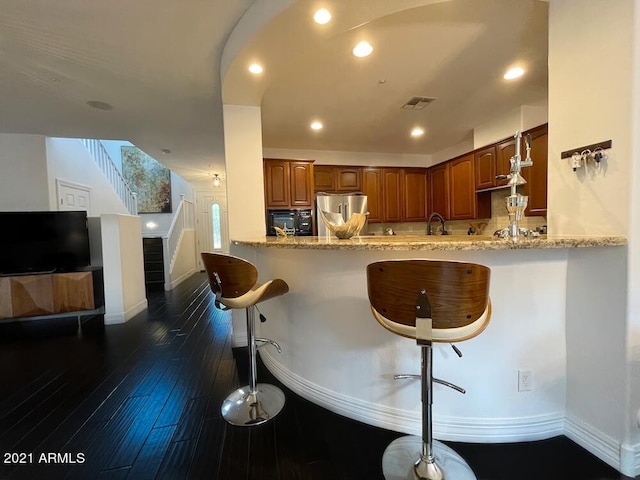 18507 N 94th St, Scottsdale, AZ 85255 - kitchen with a peninsula, a kitchen breakfast bar, visible vents, baseboards, and stainless steel refrigerator