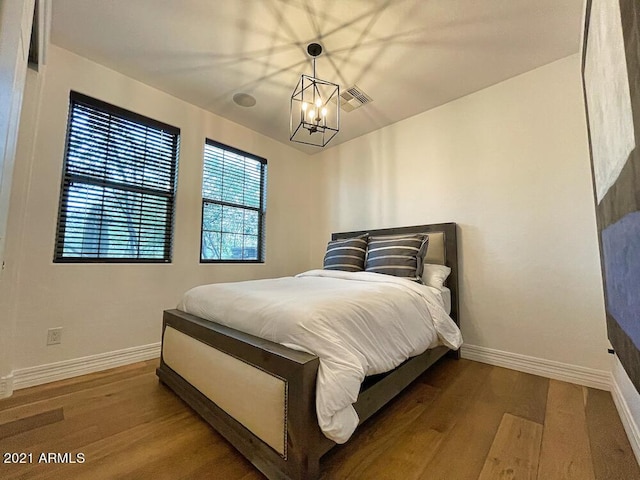 18507 N 94th St, Scottsdale, AZ 85255 - bedroom featuring an inviting chandelier, visible vents, wood finished floors, and baseboards