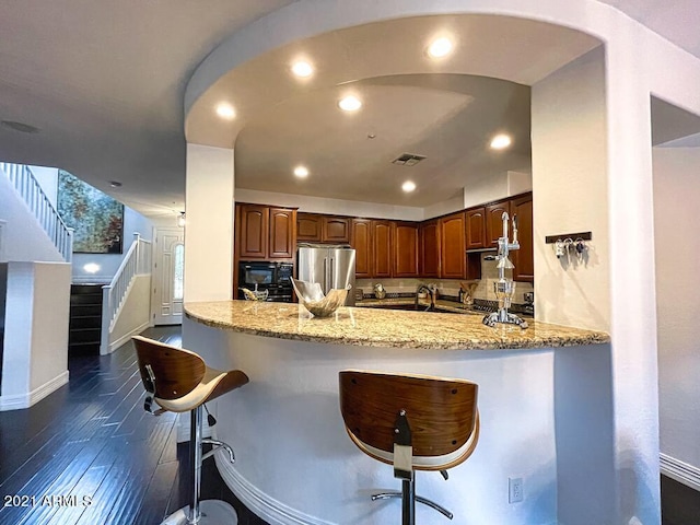 18507 N 94th St, Scottsdale, AZ 85255 - kitchen featuring freestanding refrigerator, light stone counters, a breakfast bar area, visible vents, and black microwave