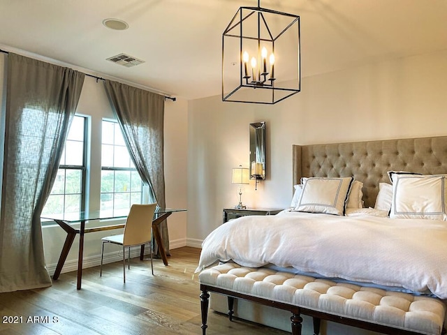 18507 N 94th St, Scottsdale, AZ 85255 - bedroom with baseboards, a notable chandelier, visible vents, and wood finished floors