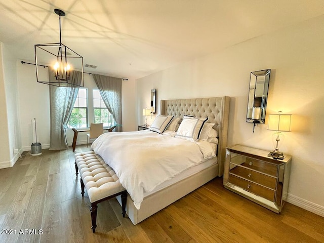 18507 N 94th St, Scottsdale, AZ 85255 - bedroom with a chandelier, baseboards, visible vents, and wood finished floors