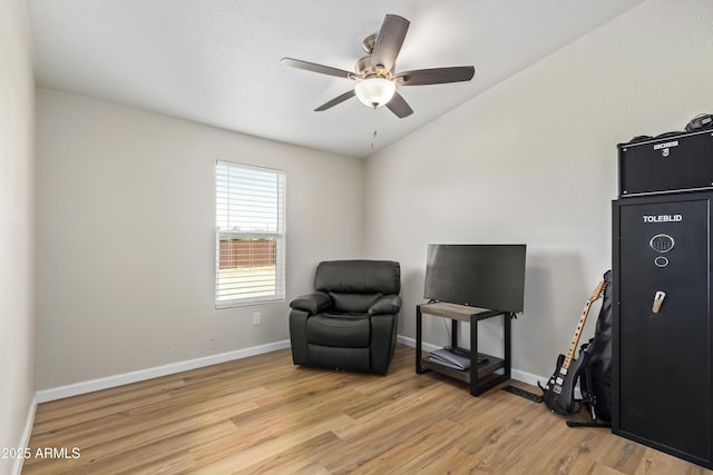 sitting room with lofted ceiling, ceiling fan, light wood-style flooring, and baseboards