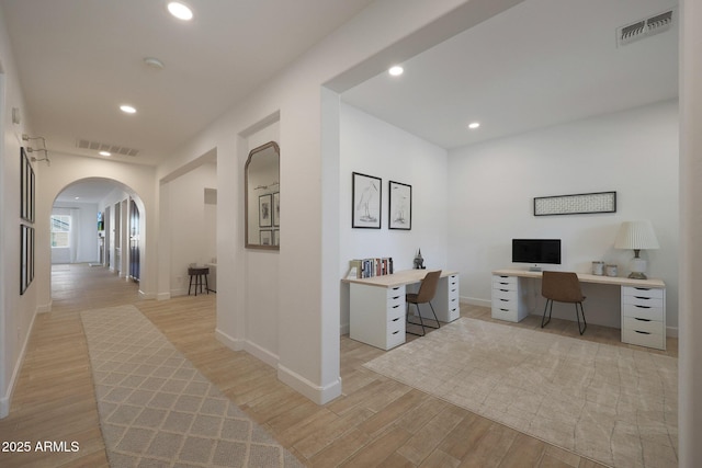 20834 W Prospector Way, Buckeye, AZ 85396 - hallway with arched walkways, light wood-style flooring, recessed lighting, a desk, and baseboards