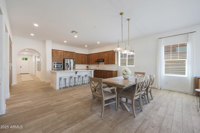 20834 W Prospector Way, Buckeye, AZ 85396 - dining space featuring arched walkways, light wood-style floors, baseboards, and recessed lighting