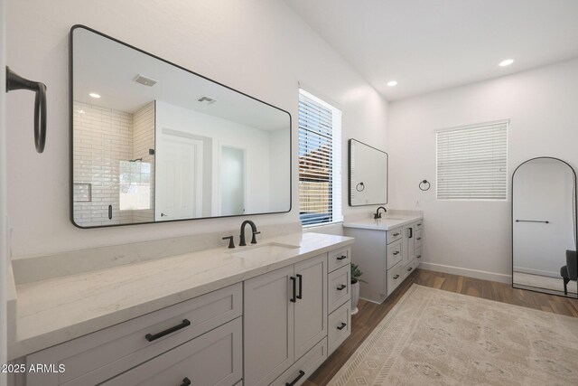 20834 W Prospector Way, Buckeye, AZ 85396 - bathroom featuring wood finished floors, a stall shower, two vanities, recessed lighting, and baseboards