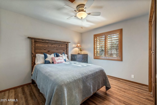 bedroom with baseboards, wood finished floors, and a ceiling fan