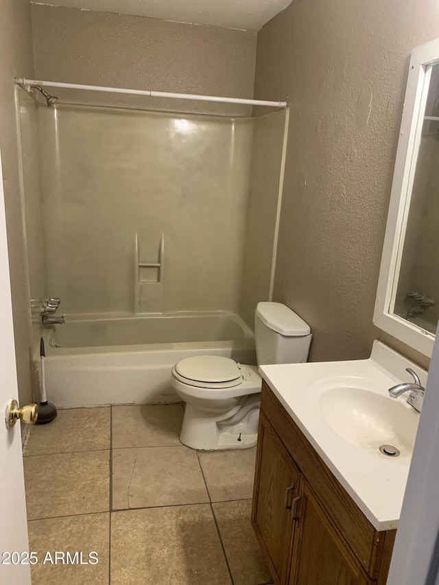 full bathroom with a textured wall, toilet, vanity, shower / bath combination, and tile patterned flooring