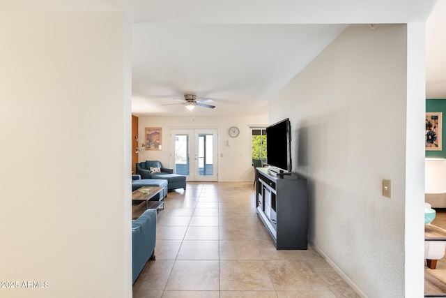 tiled living room featuring ceiling fan and french doors