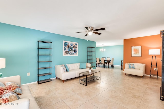 tiled living room featuring ceiling fan with notable chandelier