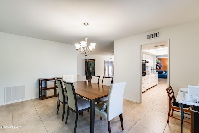 dining area featuring light tile patterned floors and an inviting chandelier