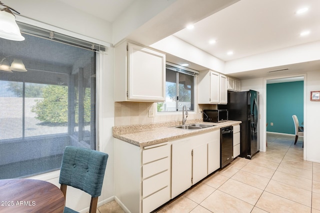 kitchen featuring sink, white cabinets, black appliances, and light tile patterned flooring