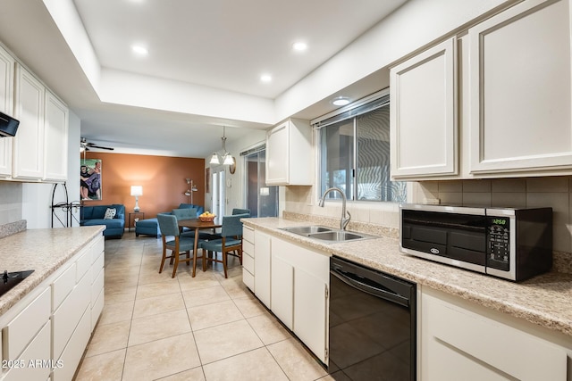 kitchen featuring hanging light fixtures, white cabinets, sink, and black dishwasher