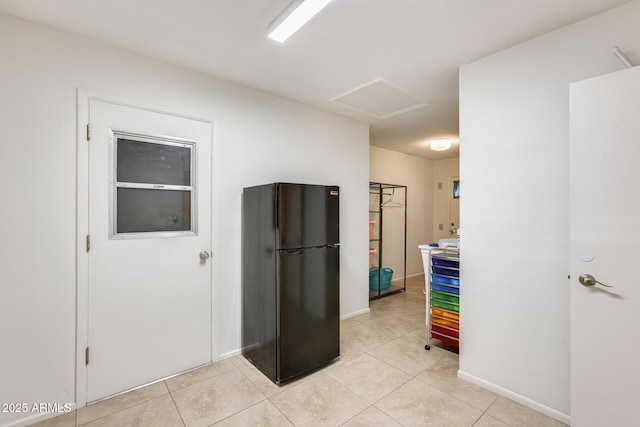 kitchen featuring black fridge and light tile patterned flooring