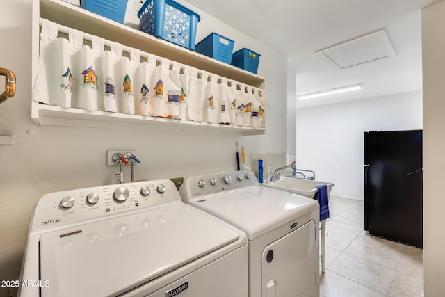 clothes washing area with separate washer and dryer, light tile patterned floors, and sink