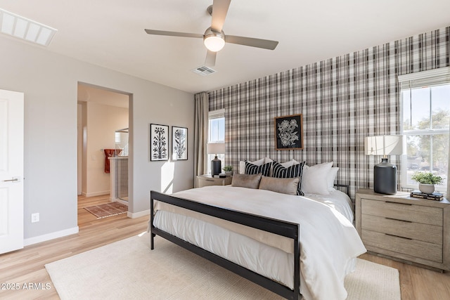 645 N Vine St, Chandler, AZ 85225 - bedroom featuring an accent wall, baseboards, wallpapered walls, light wood-style flooring, and connected bathroom