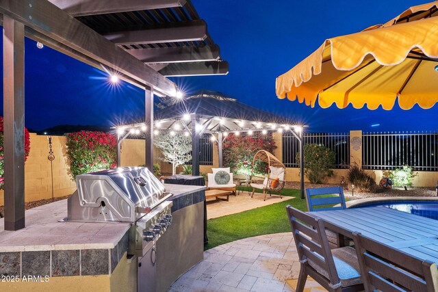 1829 N Atwood, Mesa, AZ 85207 - patio at twilight with grilling area, outdoor dining area, fence, and exterior kitchen