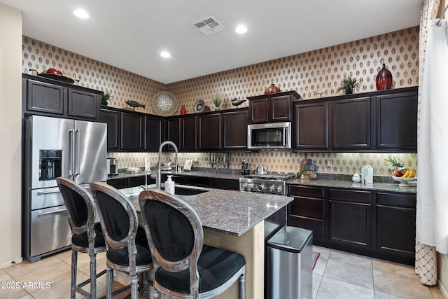 1829 N Atwood, Mesa, AZ 85207 - kitchen featuring dark stone countertops, visible vents, a sink, appliances with stainless steel finishes, and wallpapered walls