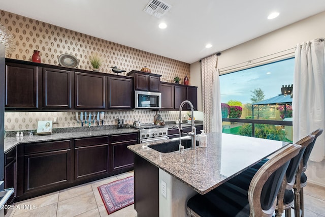 1829 N Atwood, Mesa, AZ 85207 - kitchen with visible vents, a sink, wallpapered walls, light stone counters, and stainless steel appliances