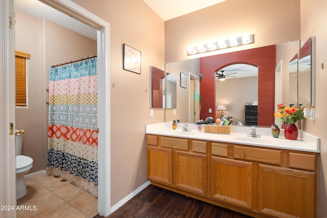 bathroom with double vanity, hardwood / wood-style floors, ceiling fan, and toilet