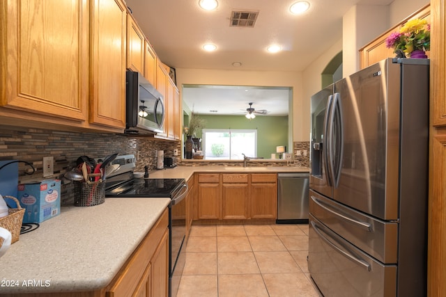 kitchen featuring light tile flooring, appliances with stainless steel finishes, sink, tasteful backsplash, and ceiling fan