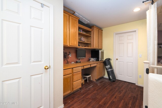 home office featuring built in desk and dark wood-type flooring