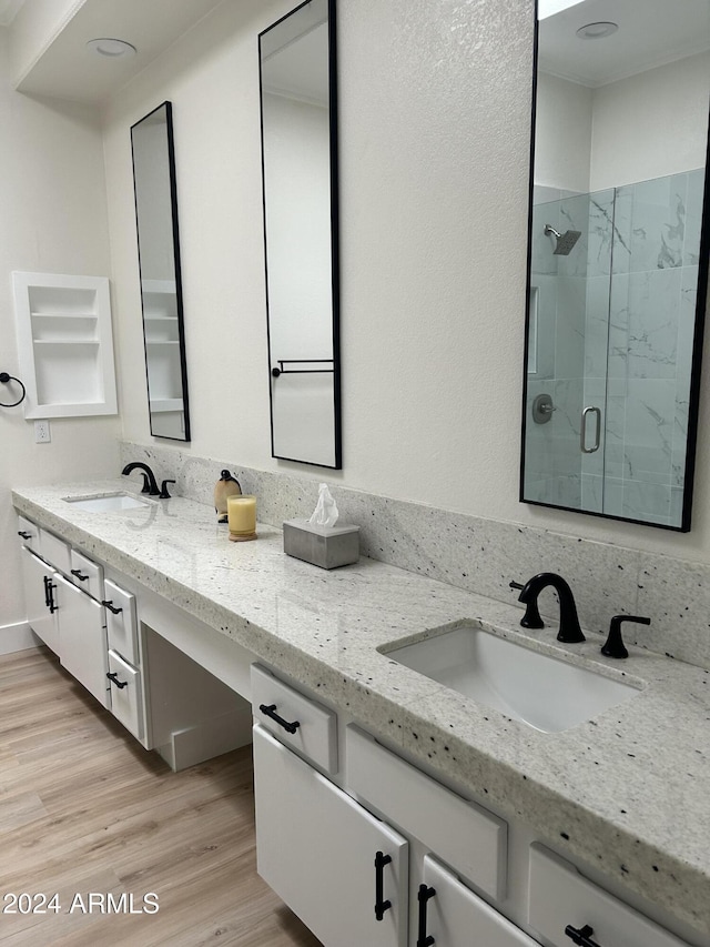 bathroom featuring vanity, hardwood / wood-style flooring, and a shower with shower door