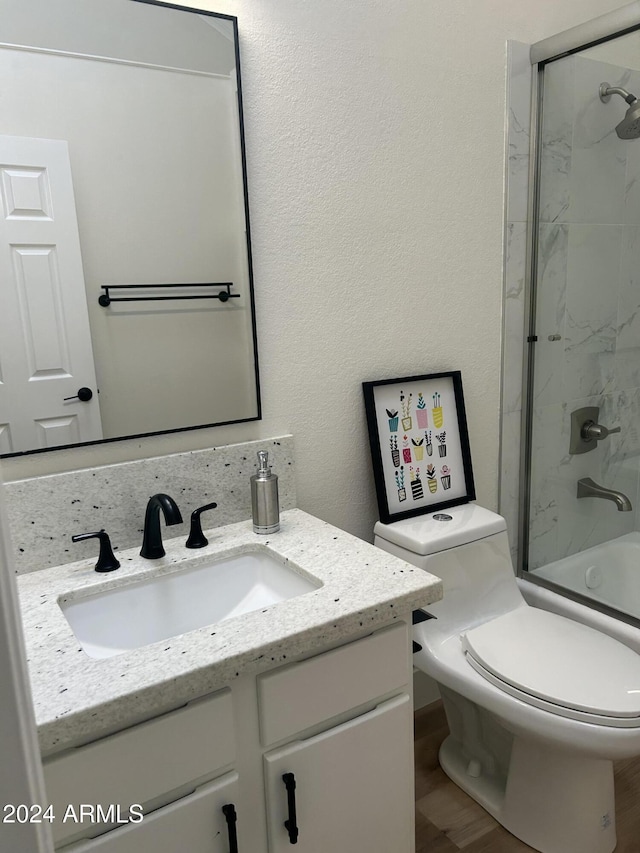 full bathroom with toilet, vanity, combined bath / shower with glass door, and hardwood / wood-style flooring