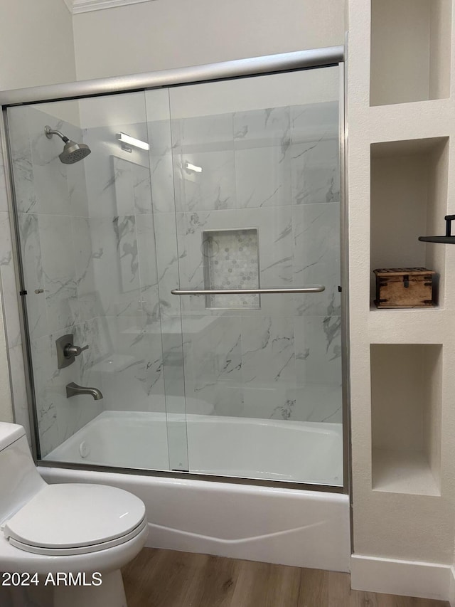 bathroom featuring hardwood / wood-style floors, toilet, and enclosed tub / shower combo