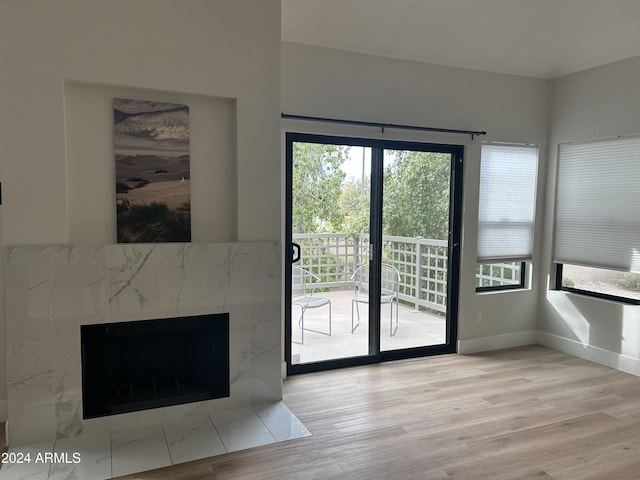 doorway with a high end fireplace and light wood-type flooring