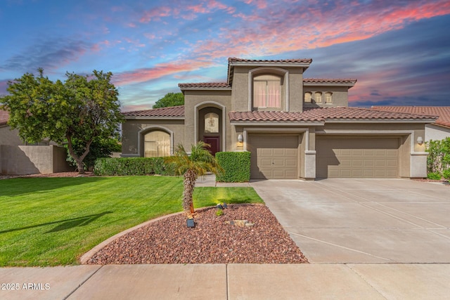 mediterranean / spanish house with stucco siding, driveway, a tiled roof, and a yard