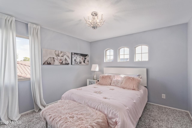 bedroom with a notable chandelier, carpet, and baseboards