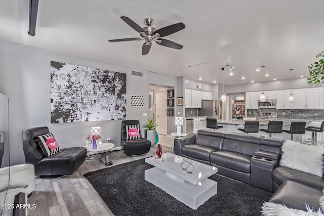 living area featuring recessed lighting, ceiling fan, wood finished floors, and visible vents