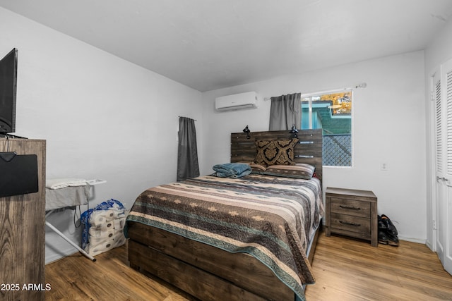 bedroom featuring wood-type flooring and a wall unit AC