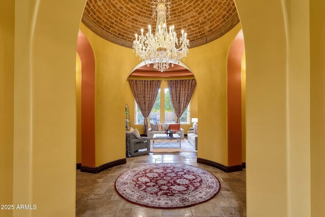 4301 E Taurus Pl, Chandler, AZ 85249 - entryway with arched walkways, a chandelier, brick ceiling, and stone tile flooring