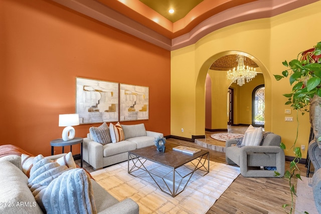 4301 E Taurus Pl, Chandler, AZ 85249 - living room with arched walkways, a high ceiling, wood finished floors, and a chandelier