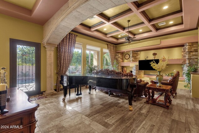 living area with decorative columns, coffered ceiling, beamed ceiling, a high ceiling, and crown molding