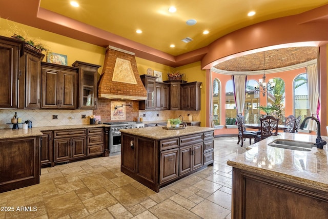 4301 E Taurus Pl, Chandler, AZ 85249 - kitchen featuring high end stainless steel range, custom range hood, stone tile floors, recessed lighting, and hanging light fixtures