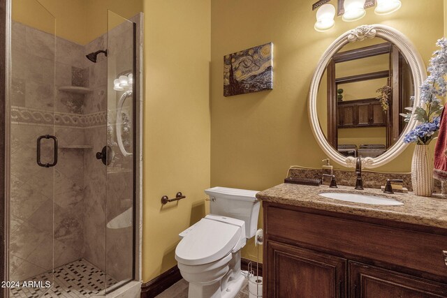 bathroom featuring toilet, a shower stall, and vanity