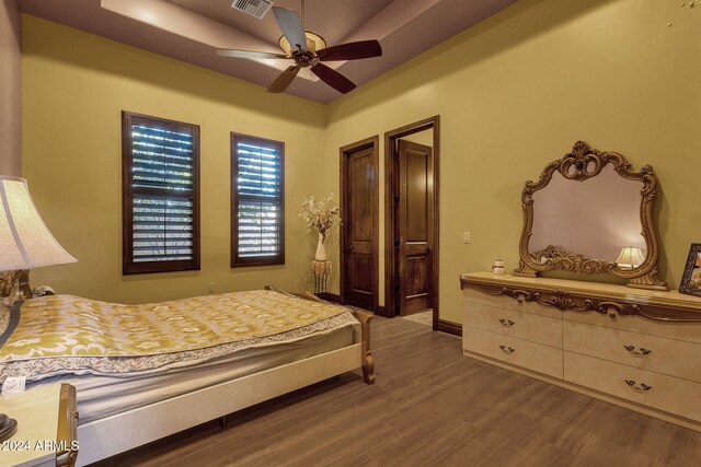 bedroom with wood finished floors, visible vents, and a ceiling fan