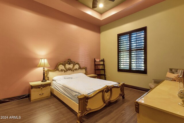 bedroom with ceiling fan, baseboards, and wood finished floors