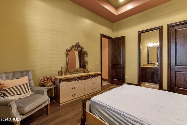 bedroom with baseboards, dark wood-style flooring, and ensuite bathroom