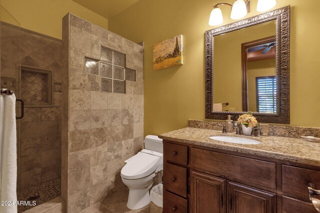 full bath with tiled shower, vanity, toilet, and tile patterned floors