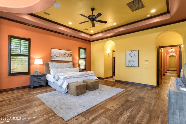 4301 E Taurus Pl, Chandler, AZ 85249 - bedroom featuring arched walkways, a raised ceiling, crown molding, wood finished floors, and recessed lighting