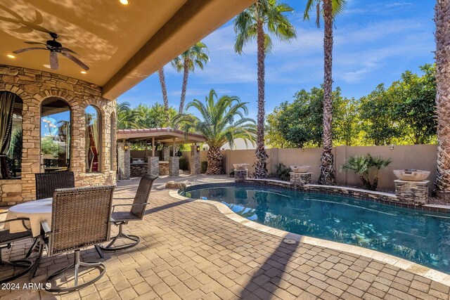 view of swimming pool with a fenced backyard, a ceiling fan, a fenced in pool, outdoor dining space, and a patio area