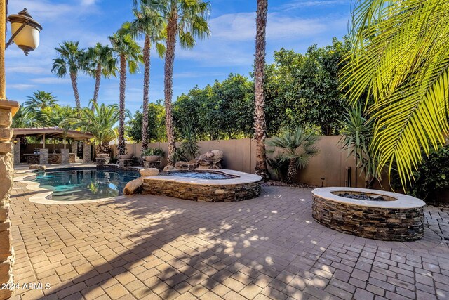 view of pool featuring a fire pit, a fenced in pool, a patio, a fenced backyard, and an in ground hot tub