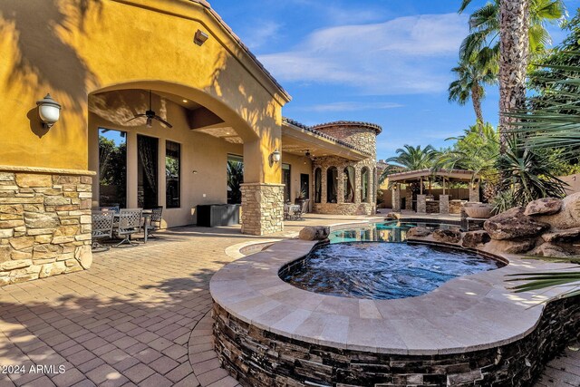 outdoor pool featuring ceiling fan, an in ground hot tub, and a patio area