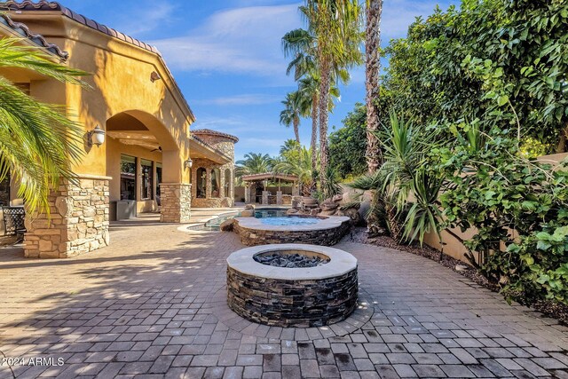 view of patio with an outdoor fire pit, a pergola, an outdoor pool, and a ceiling fan