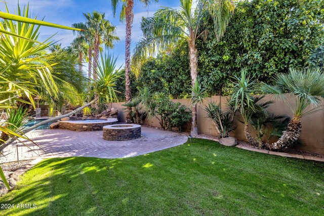 view of yard featuring a patio, an outdoor fire pit, and fence